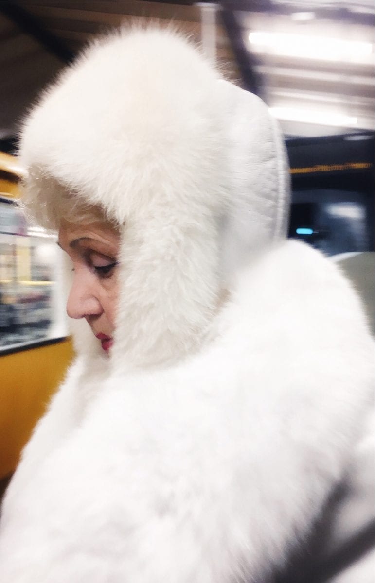 woman wearing white fur street photography of a person, by efi logginou