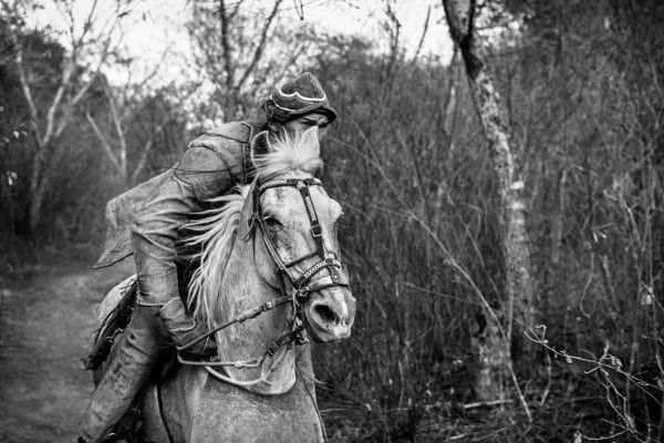 black and white photo of cowboys riding horses in chile