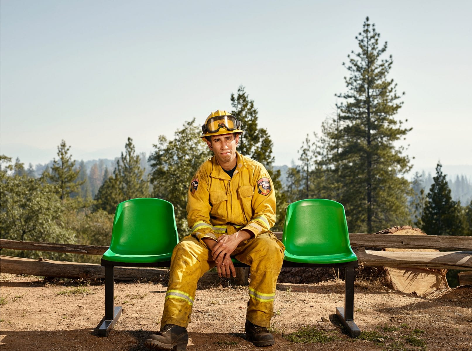 fireman sitting on a green bench, color portrait photography by dylan collard