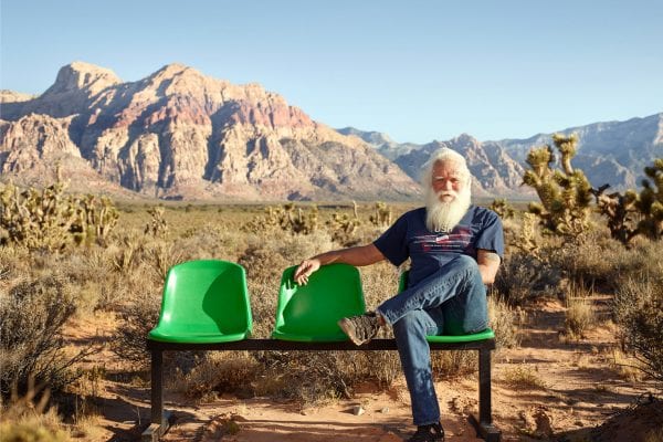 bearded man sitting on a green bench, color portrait photography by dylan collard