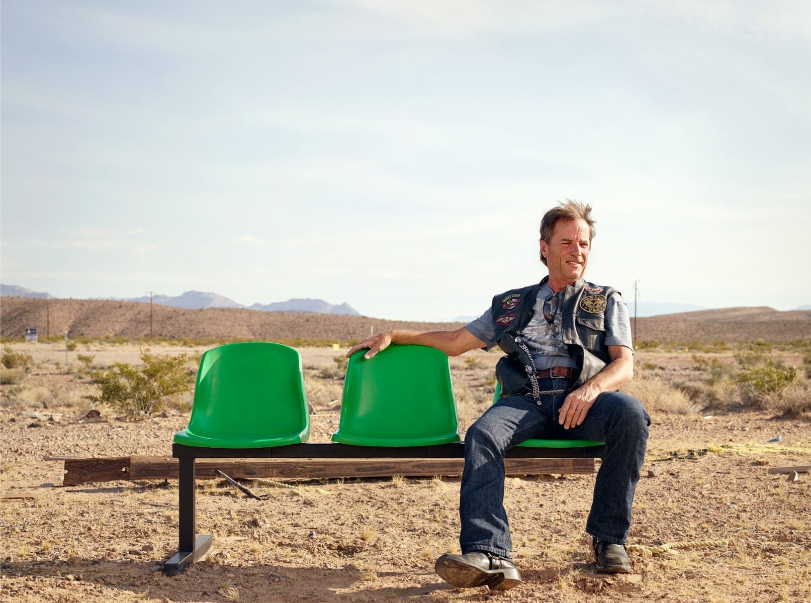 old man sitting on a green bench, color portrait photography by dylan collard