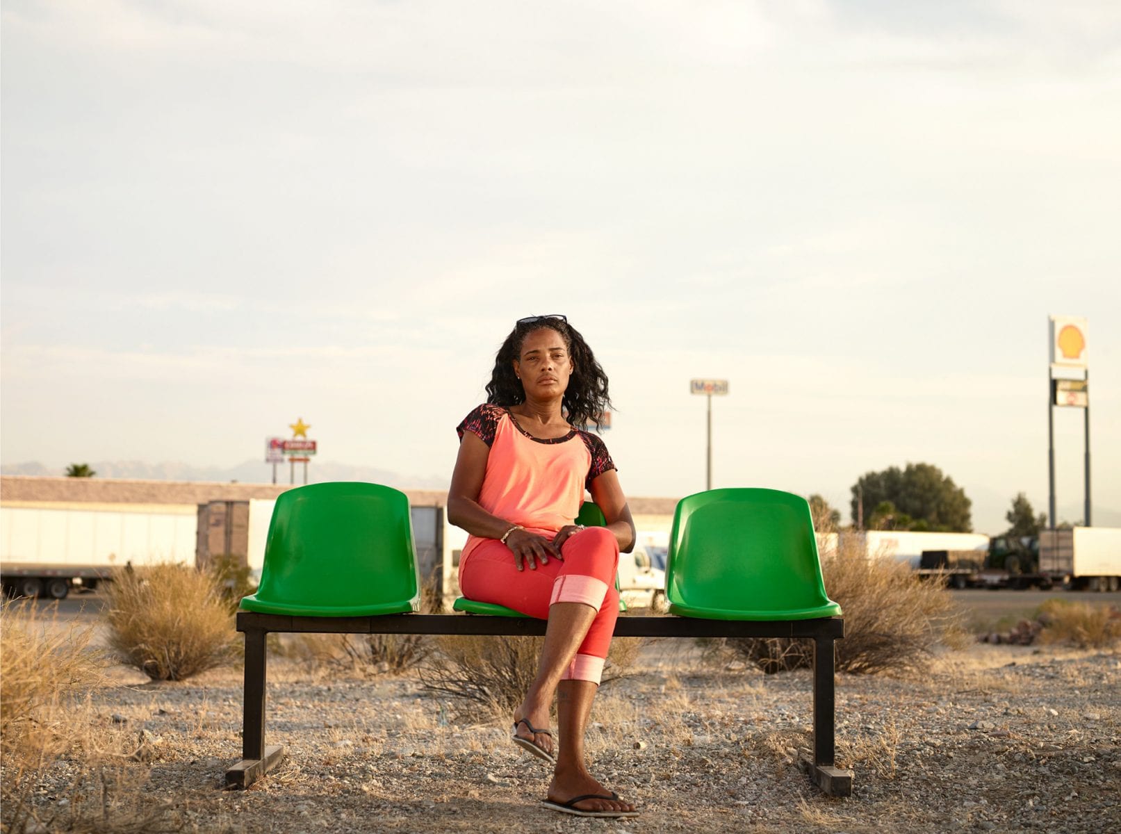 woman sitting on a green bench, color portrait photography by dylan collard