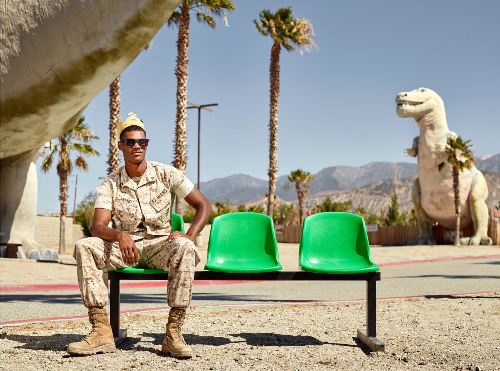 man sitting on a green bench, color portrait photography by dylan collard