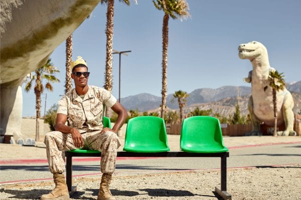 man sitting on a green bench, color portrait photography by dylan collard