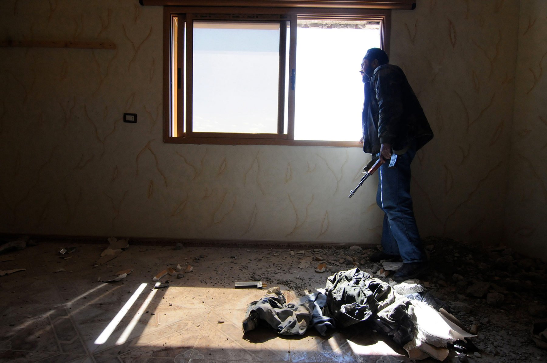 An FSA fighter is on the look out from inside a defensive position after government forces just shelled the area with tanks 80km North of Damascus - Syria, April 25, 2013 , by Jonathan Alpeyrie