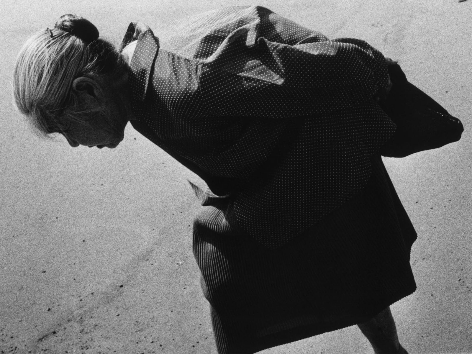 black and white portrait of an elderly woman walking in Tokyo, Japan. Photograph by Issei Suda