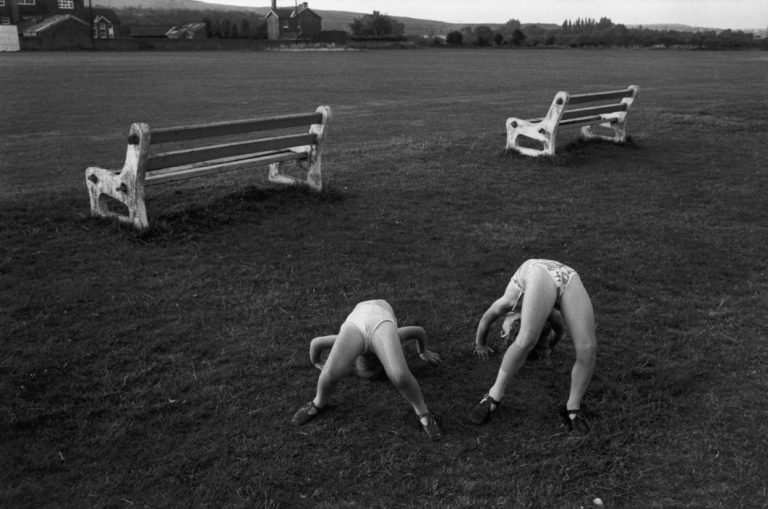 Black and white street photography by Richard Kalvar of kids playing in the grass. Shot in New York, Long Island