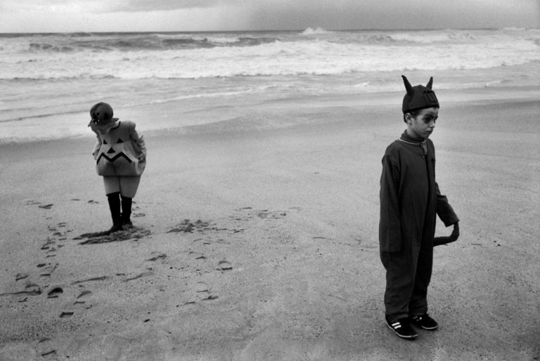 Black and white street photography by Richard Kalvar, two children in fancy dress on the beach in Biarritz, France.