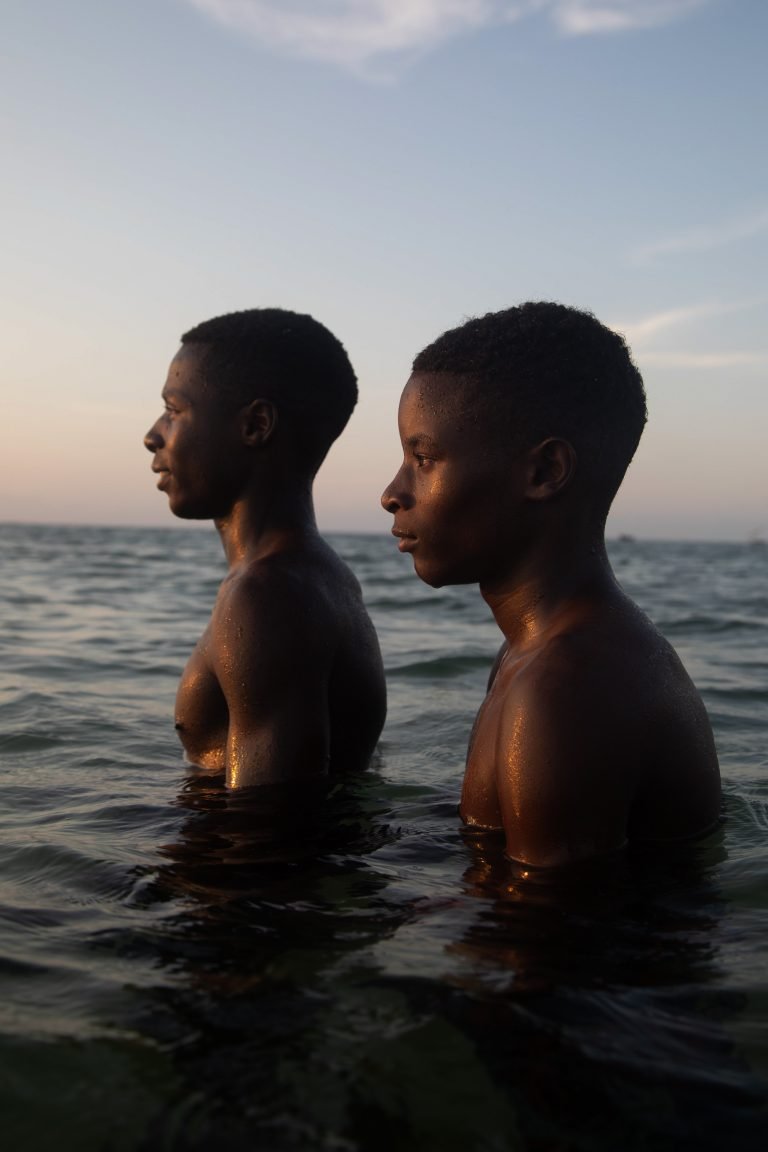 Color photo by Yzza Slaoui of two boys in the sea. Bazaruto, Mozambique