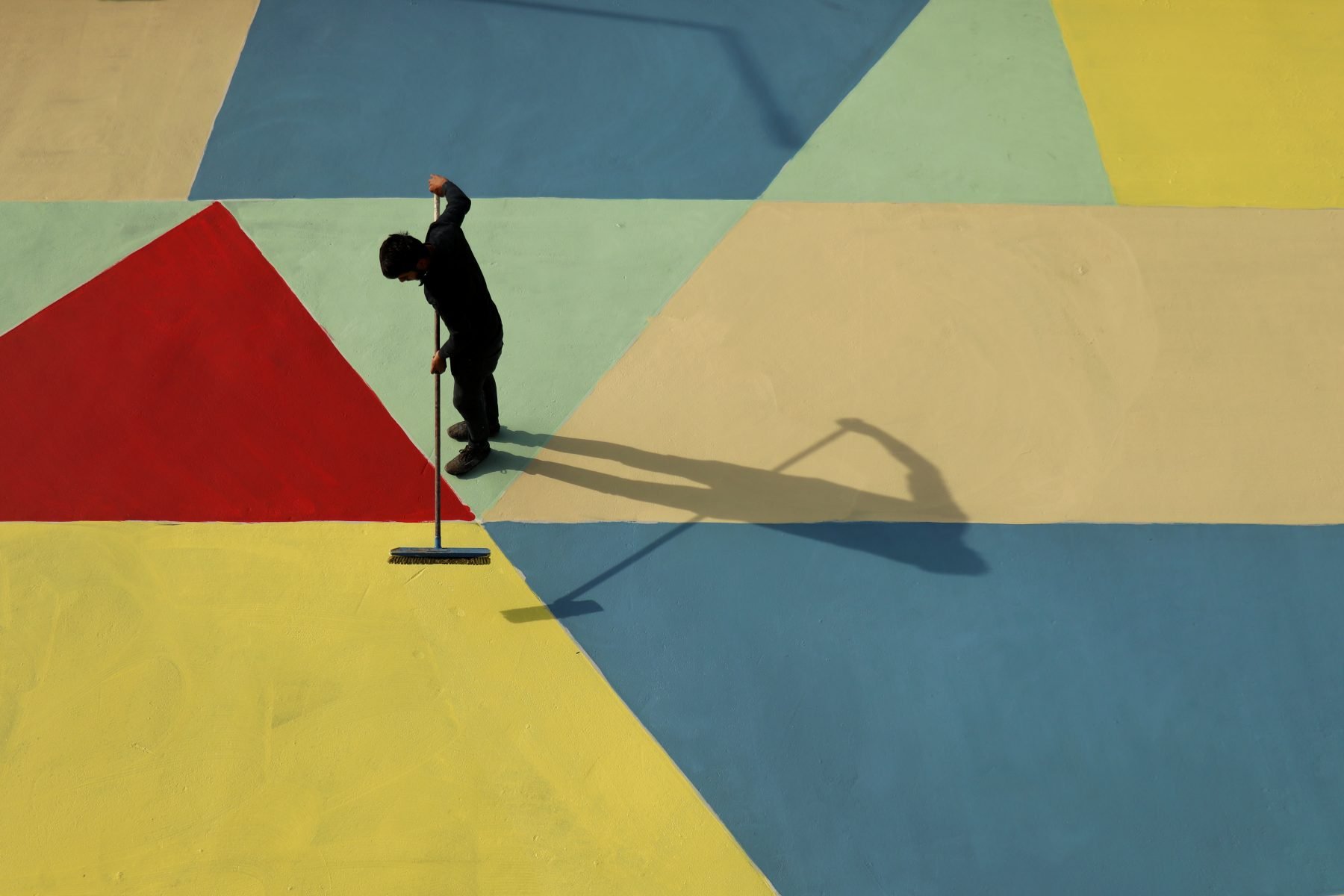 Photographer of man painting street in bright colors in Istanbul, Turkey by Ali Önal