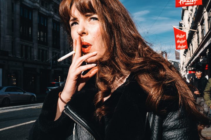 Portrait photograph of a woman with red lipstick and blue eyes in Oxford Street, London, UK by Francesco Gioia