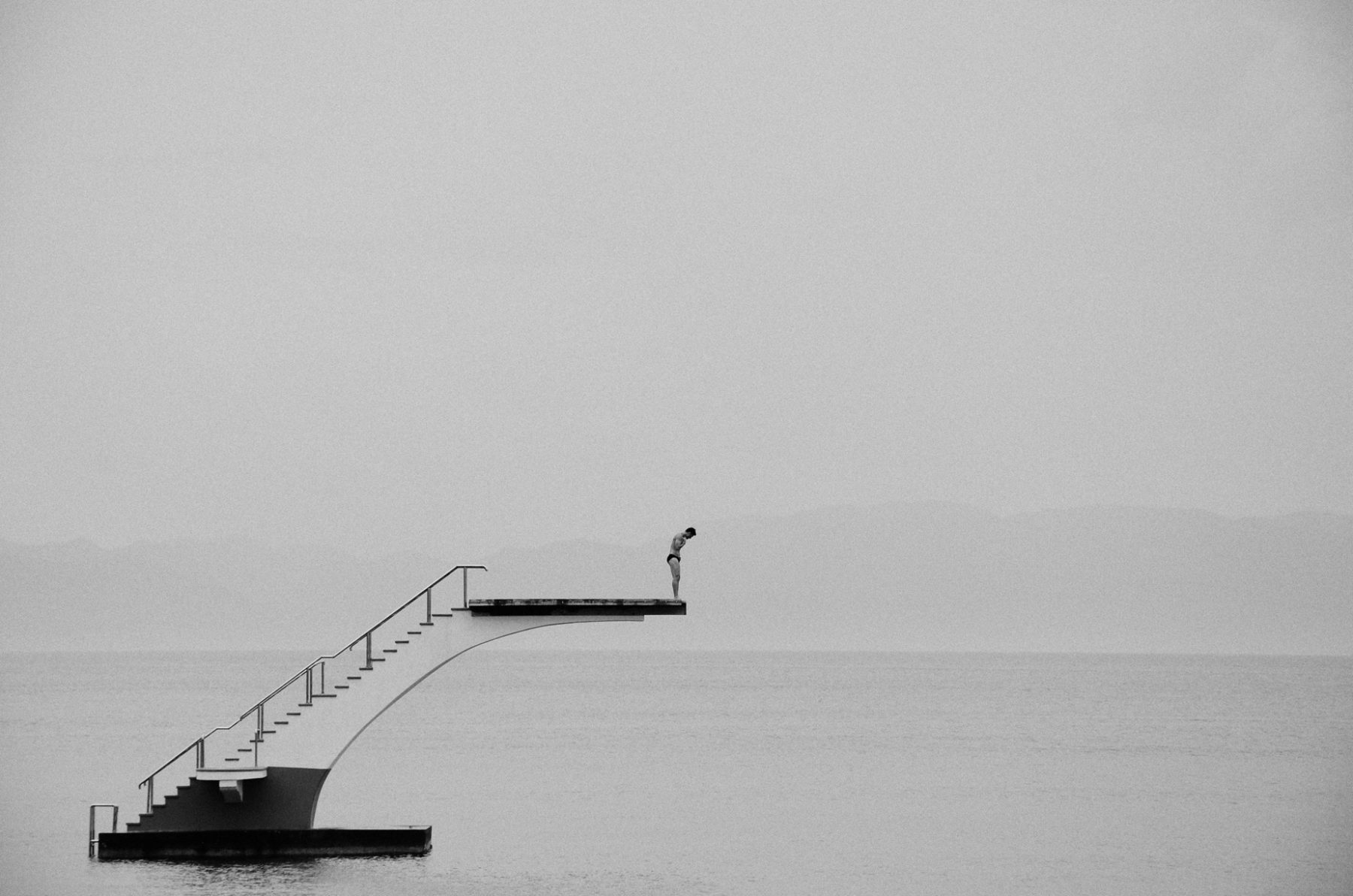 Open Call - black and white photograph of a man diving in the sea in Rhodes, Greece