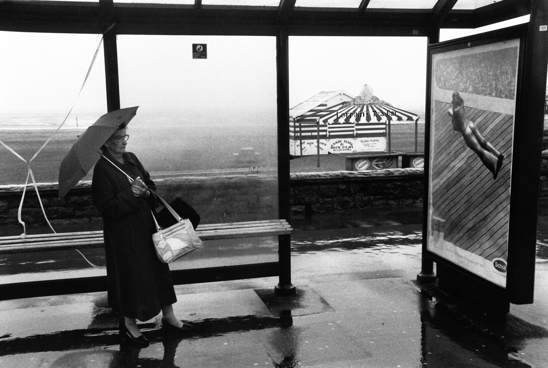 Black and white photography, woman at bus stop with umbrella. Roger Deakins, Byways