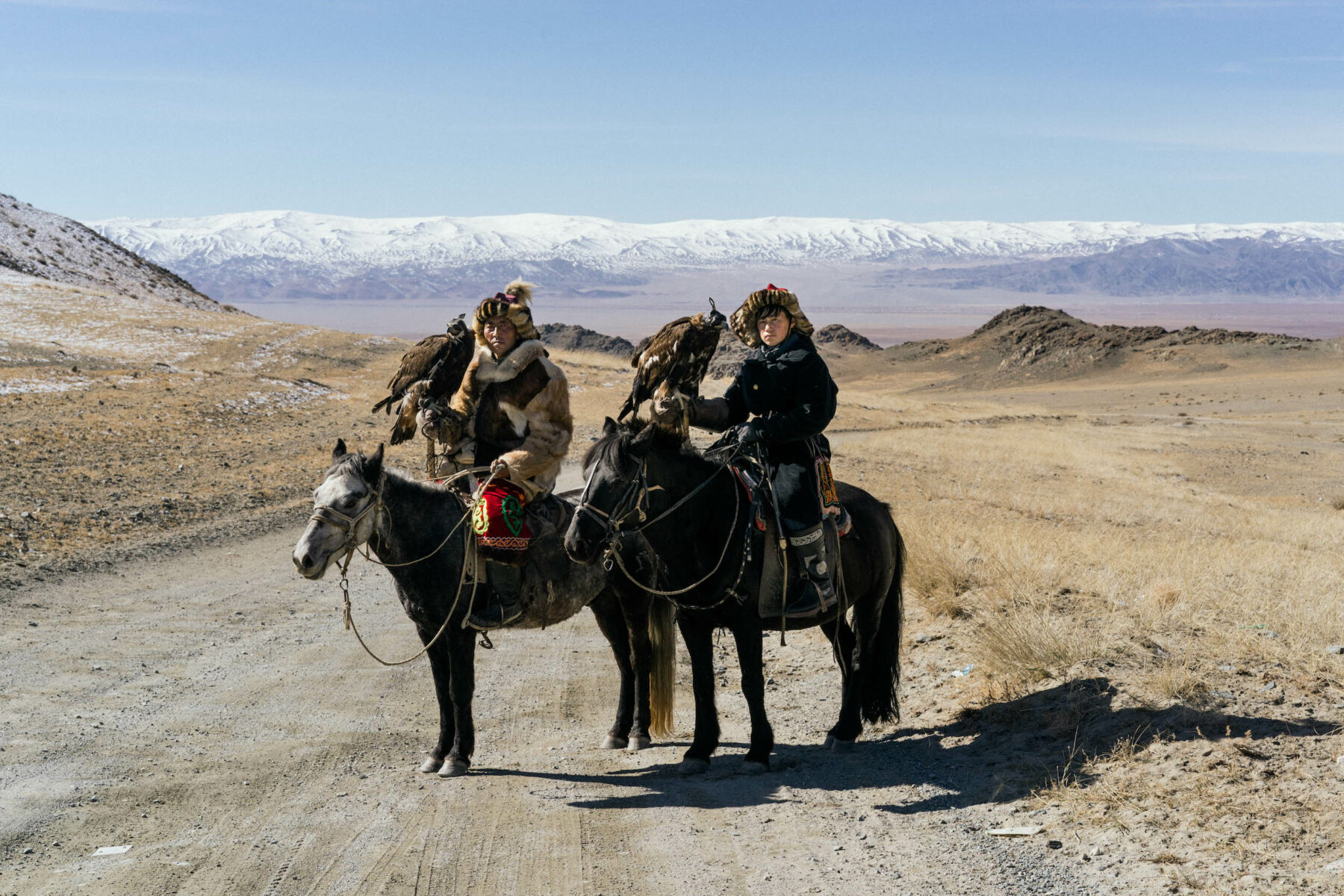 Documentary photography by Hannah Reyes Morales, from the series 'Eagle Hunters'. Haidar Huanjol, 47 years old and Talgat Ersultan, 15 years old, are photographed on their way to the Golden Eagle Festival in Bayan Ulgii, Mongolia, where more than 100 eagle hunters gathered to compete