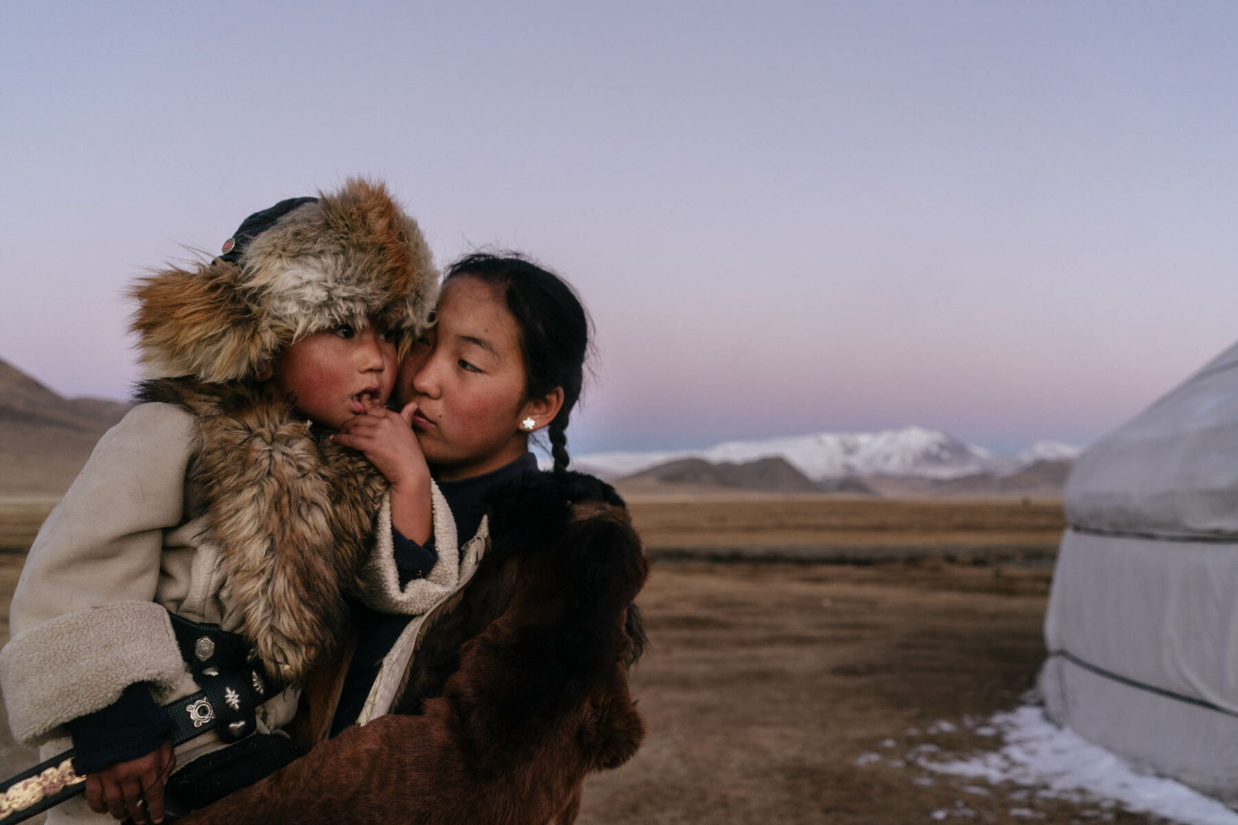 Talap Zamanbol, 14, is seen with Bazarbai Dinismal, a younger relative training to be a falconer in Bayan Ulgii, Mongolia. Color photography by Hannah Reyes Morales from the series, 'Eagle Hunters'