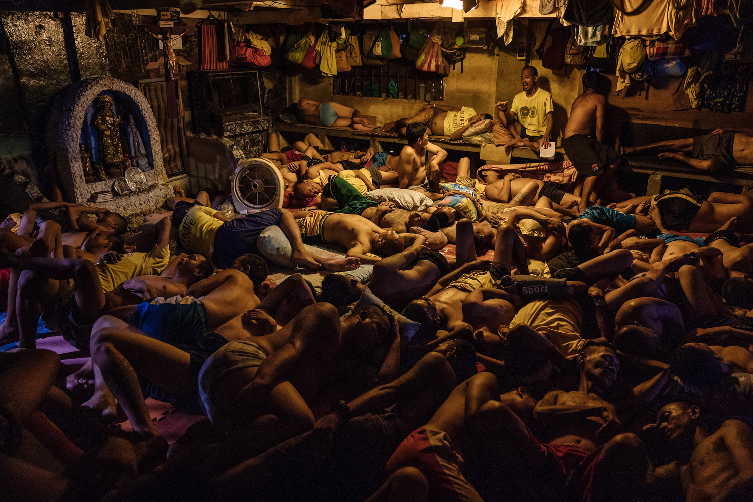 Detainees are seen sleeping by a small grotto of Mary in the Manila City Jail in Manila, Philippines on October 31, 2018.From the series, 'Manila City Jail', documentary photography by Hannah Reyes Morales