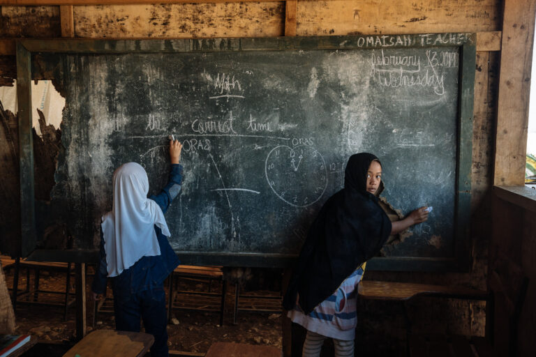 From the series, 'Marawi'. Two schoolgirls removing chalk from chalkboard, in Marawi, Philippines. Documentary photography by Hannah Reyes Morales