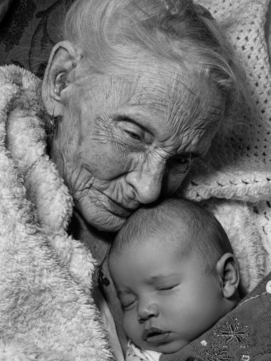 black and white close up portrait of an elderly woman and a newborn baby by Gary Lawson