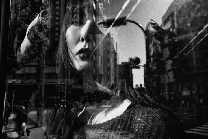 Black and white street photography by Tatsuo Suzuki. woman, reflections, city,Tokyo Japan