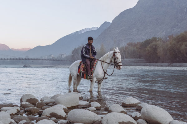 color photo of a horse and man in Northern Pakistan by Gauthier Digoutte