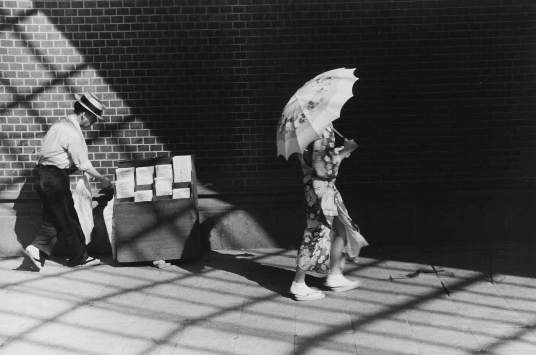 Black and white photography by Kineo Kuwabara, girl with umbrella and newspaper vendor 1936