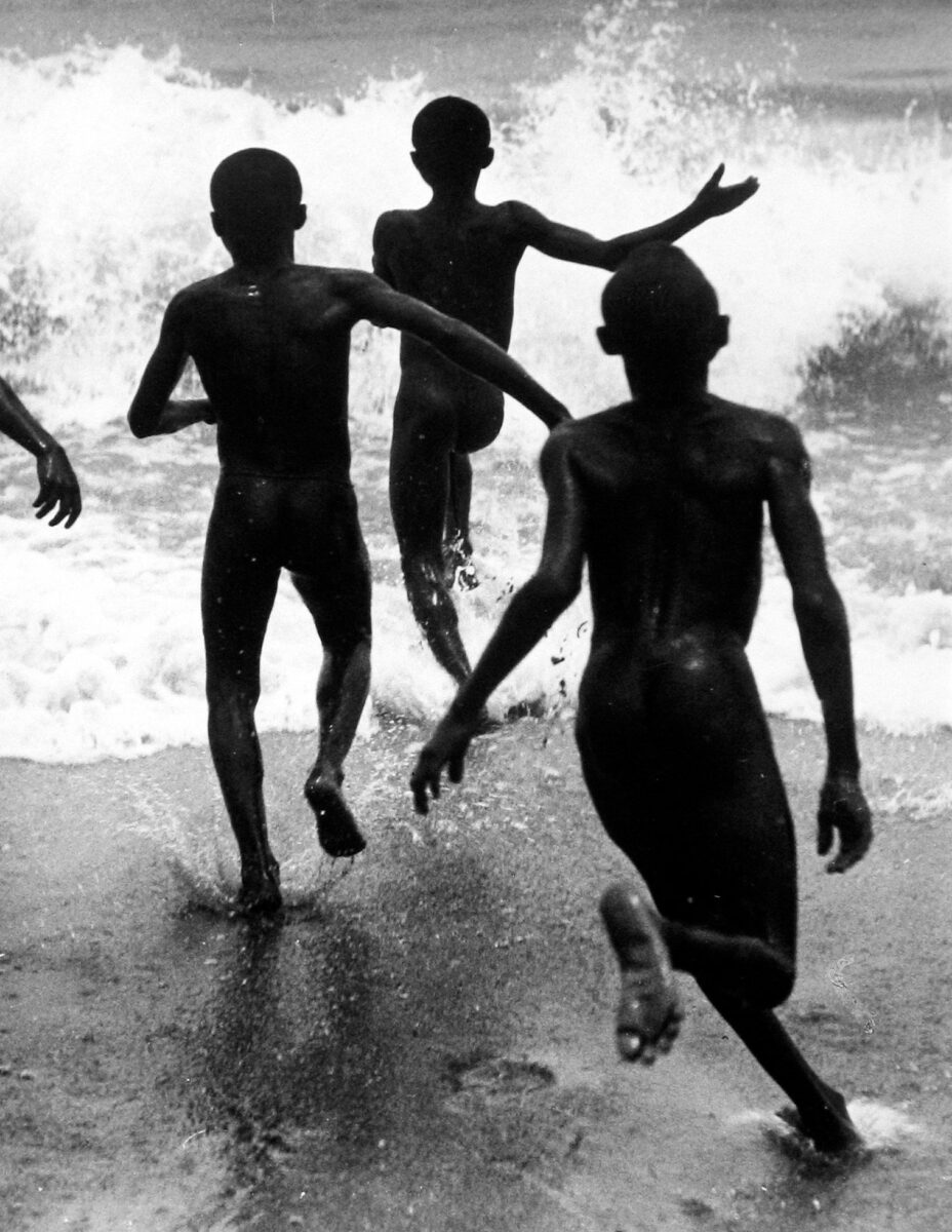 Black and white photography by Martin Munkácsi three boys running in lake.