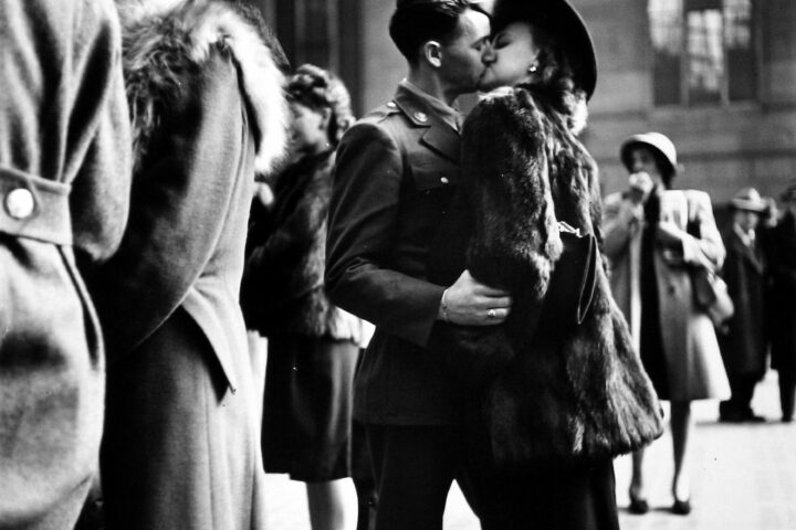 Couple in Penn Station sharing farewell kiss before he ships off to war during WWII, NY, 1943. Black and white photography by Alfred Eisenstadt