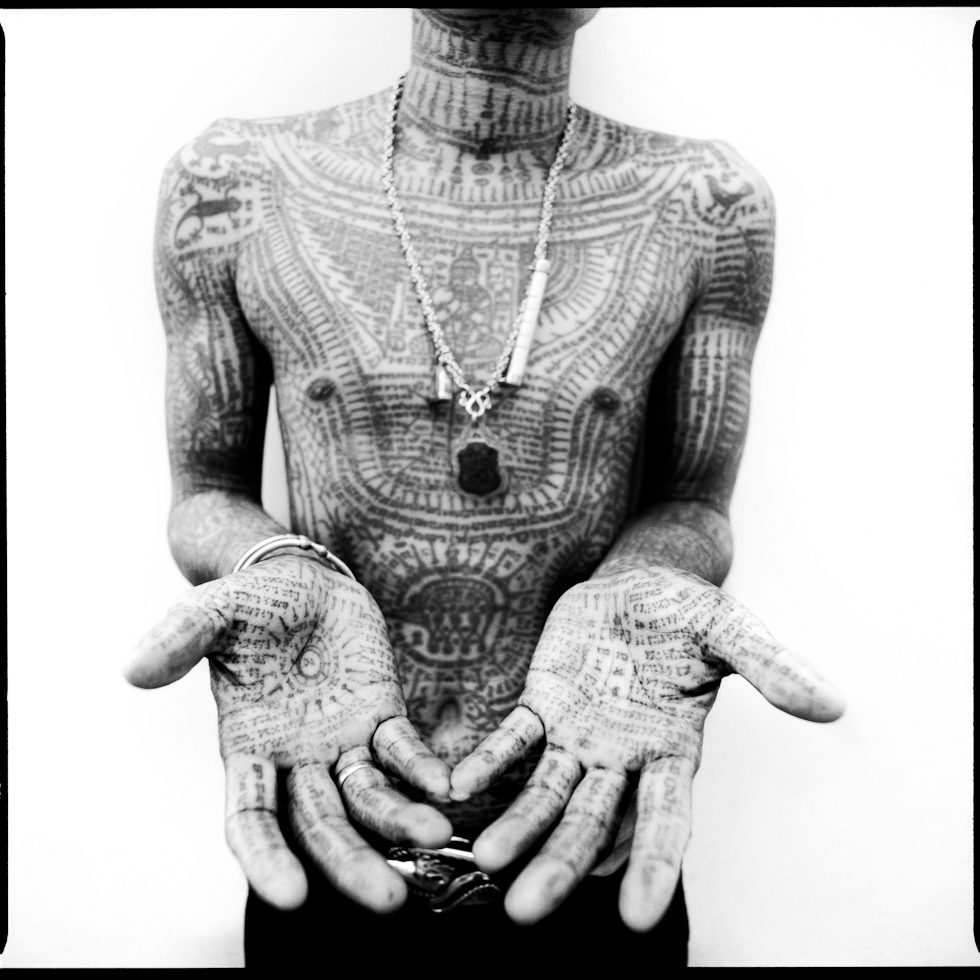 Black and white photography by Cedric Arnold, tattoos on mans hands, arms and chest