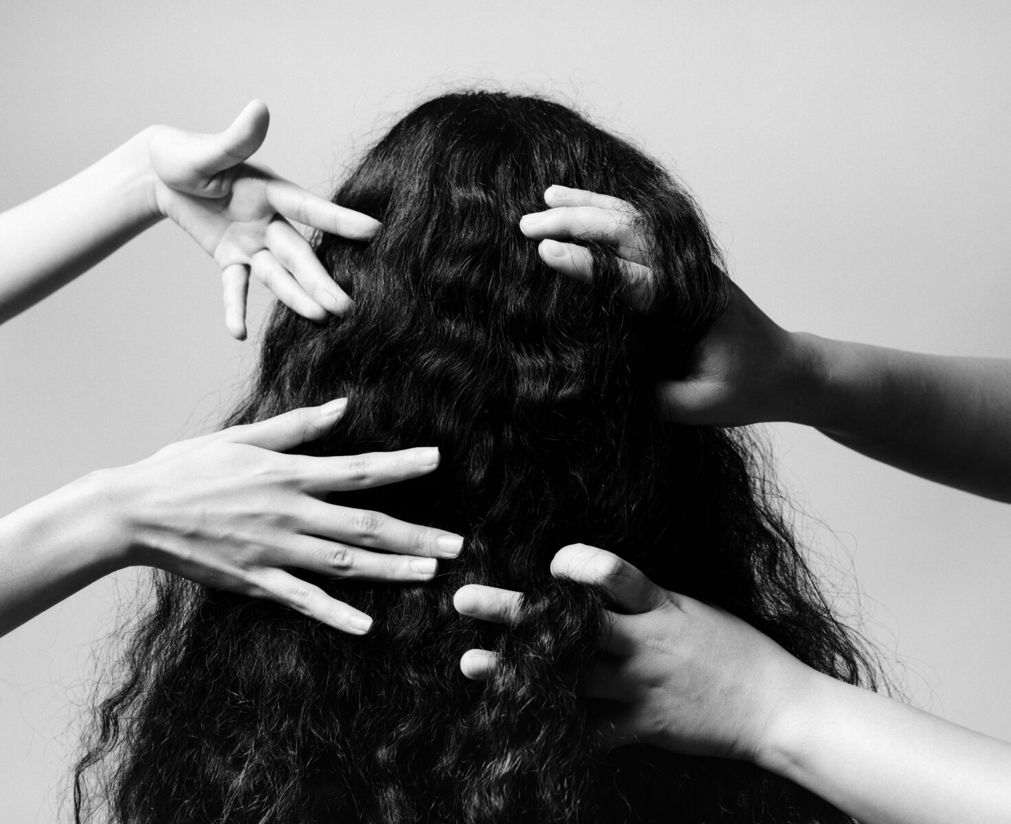 black and white photo of hands and hair by Emilio Daniel