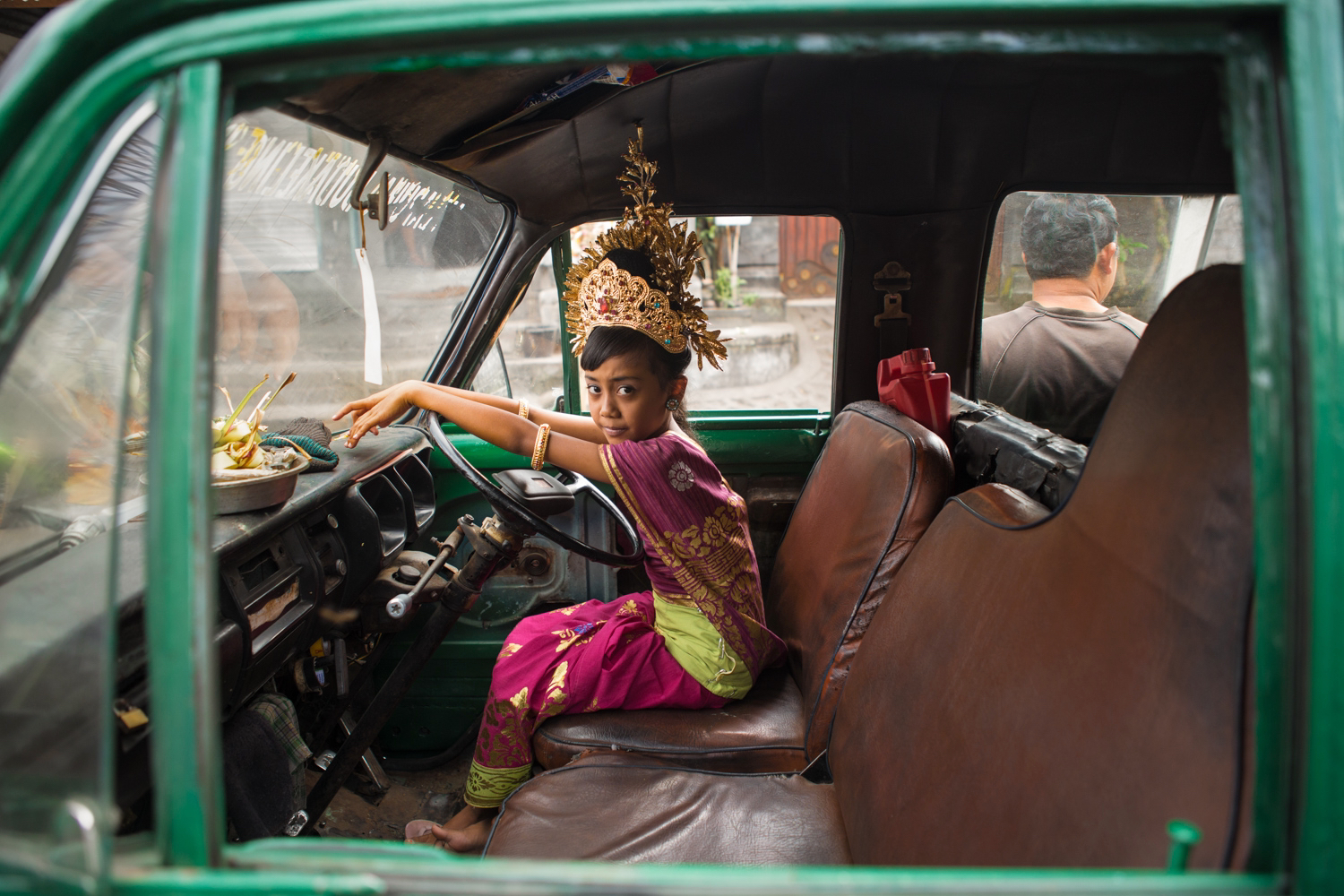 Color photography by Michael Dean Morgan, young girl in car, Bali.