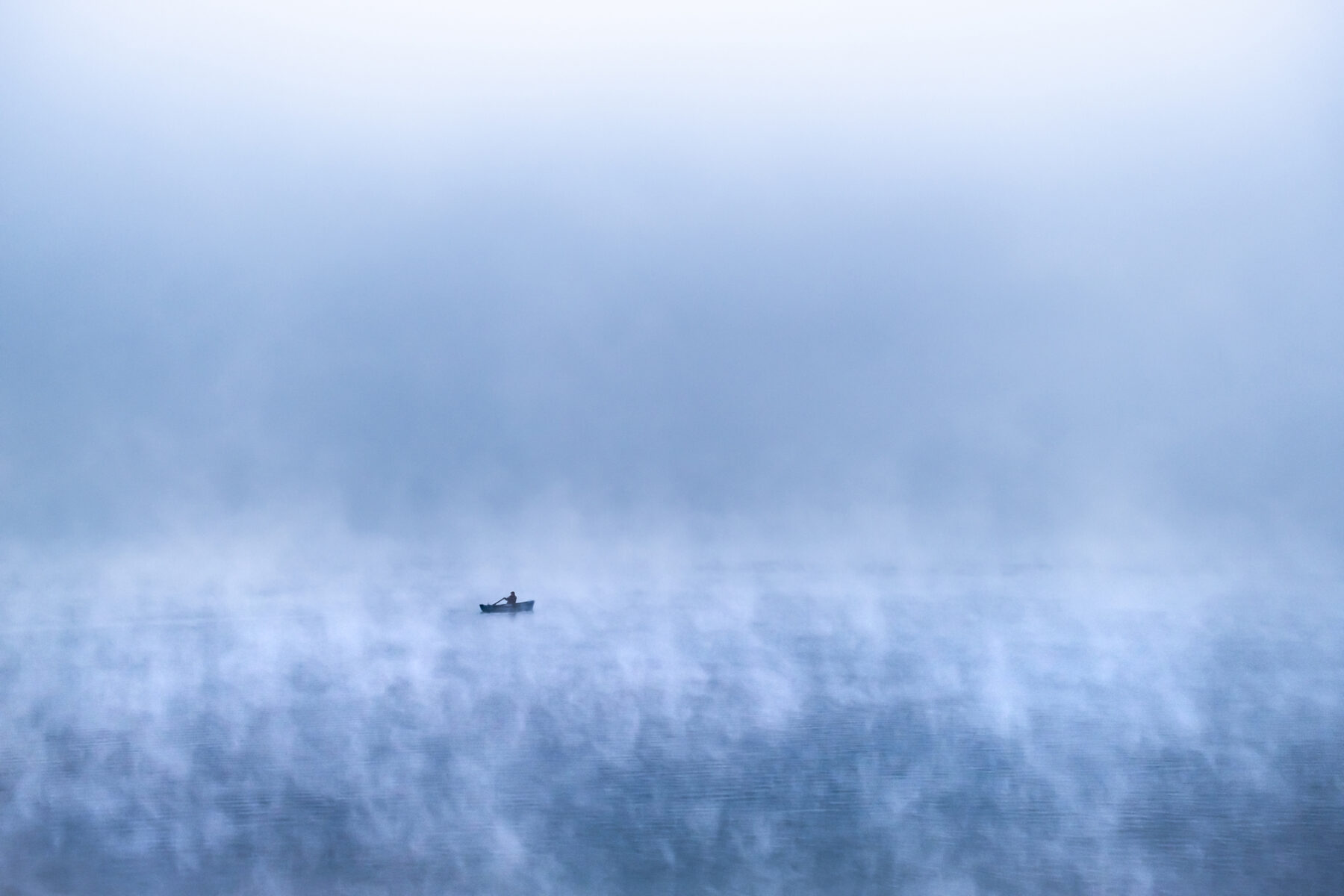 color photo of a man in boat on sea by Nicolas Castermans