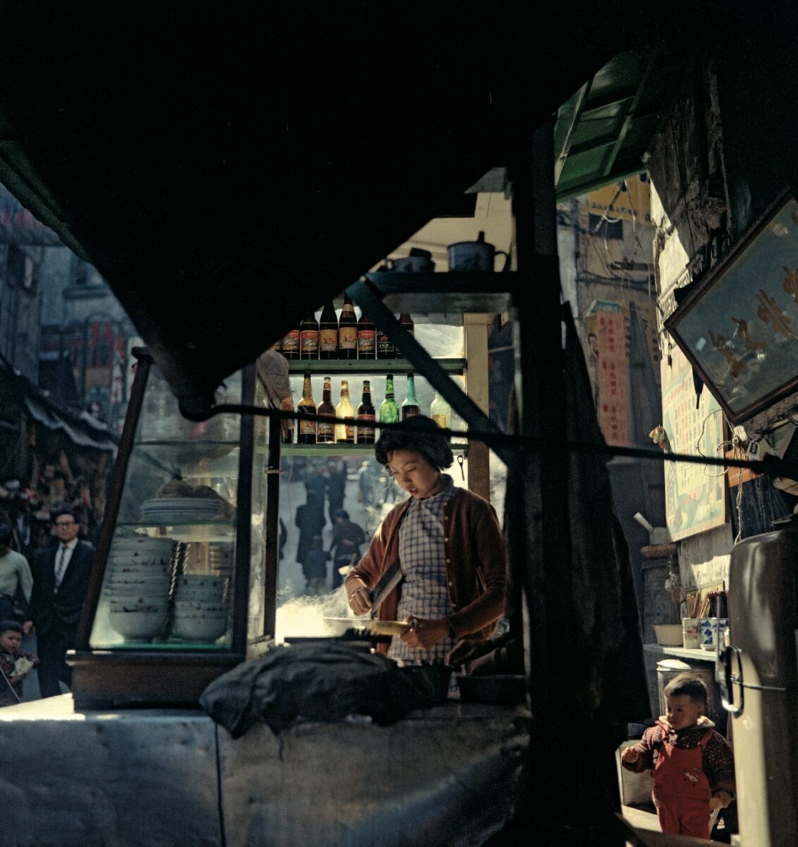 Color street photography by Fan Ho. Hong Kong market stall, women preparing food. 50s/60s