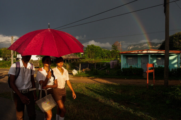 Color street photography by Andrea Torrei, schoolgirls, umbrella, rainbow, Cuba