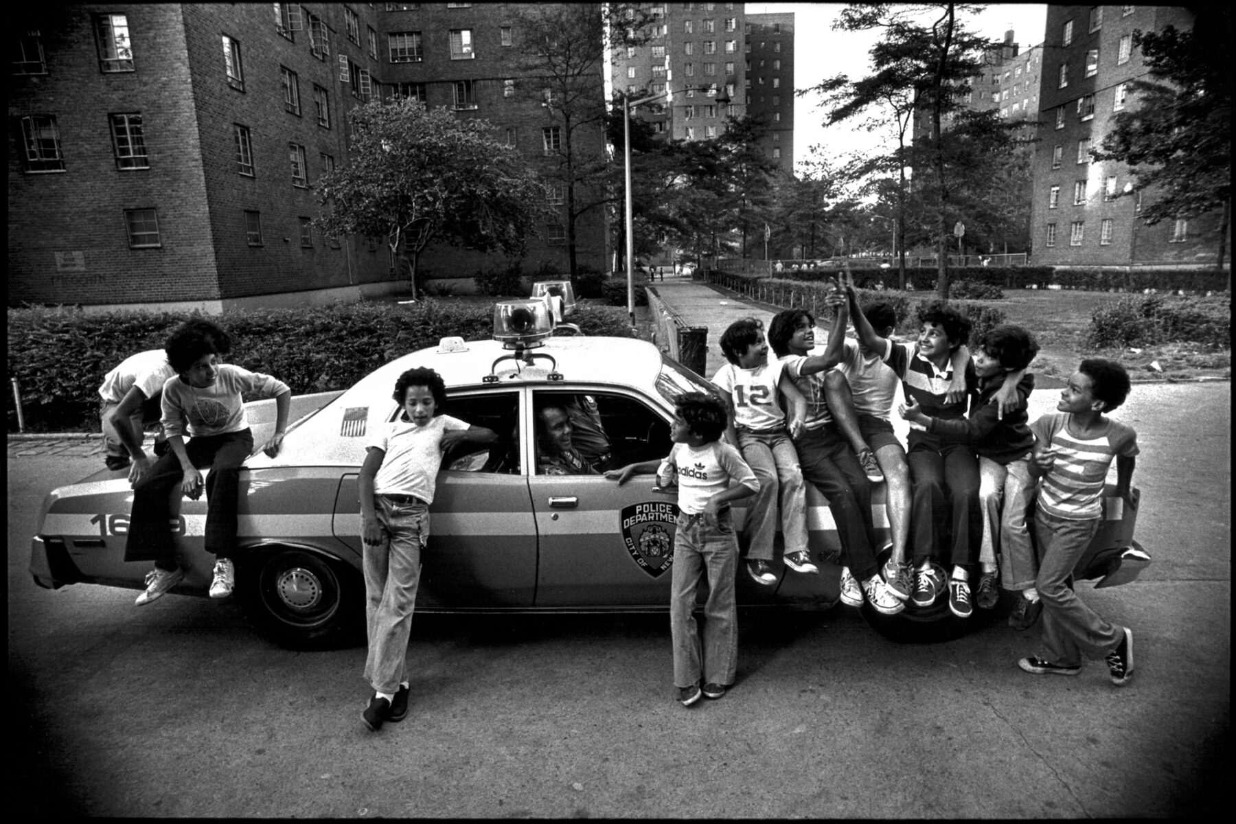 Kids on copy car, NYC, street photography by Jill Freedman from 'Street Cops'