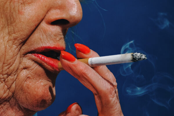 color street photo portrait of a a woman smoking in Leicester Square, London, UK by Francesco Gioia