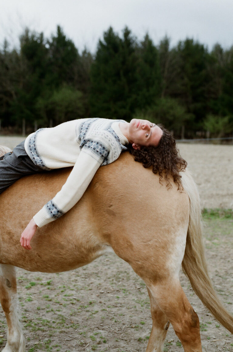 Documentary photography by Tomislav Marcijuš, portrait of guy lying on horse from the series Baranja Dreaming