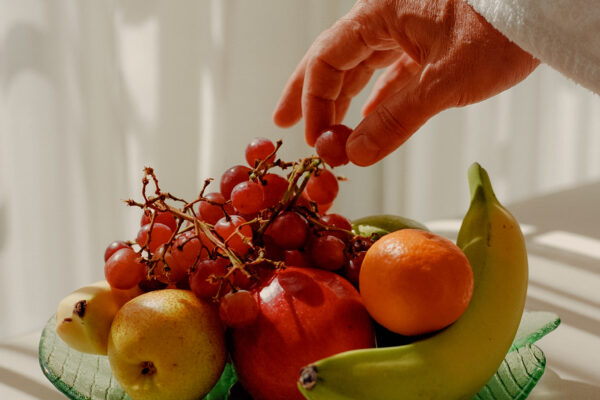 color photo of a hand with fruit bowl by Jonah Reenders