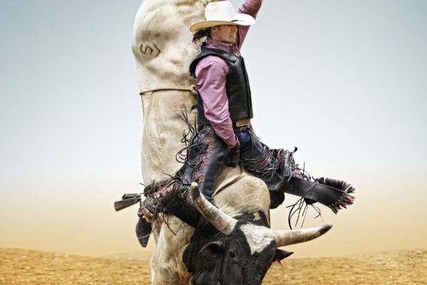 color photo of man on bull at rodeo in Mesquite, Texas, USA by Steve Wrubel