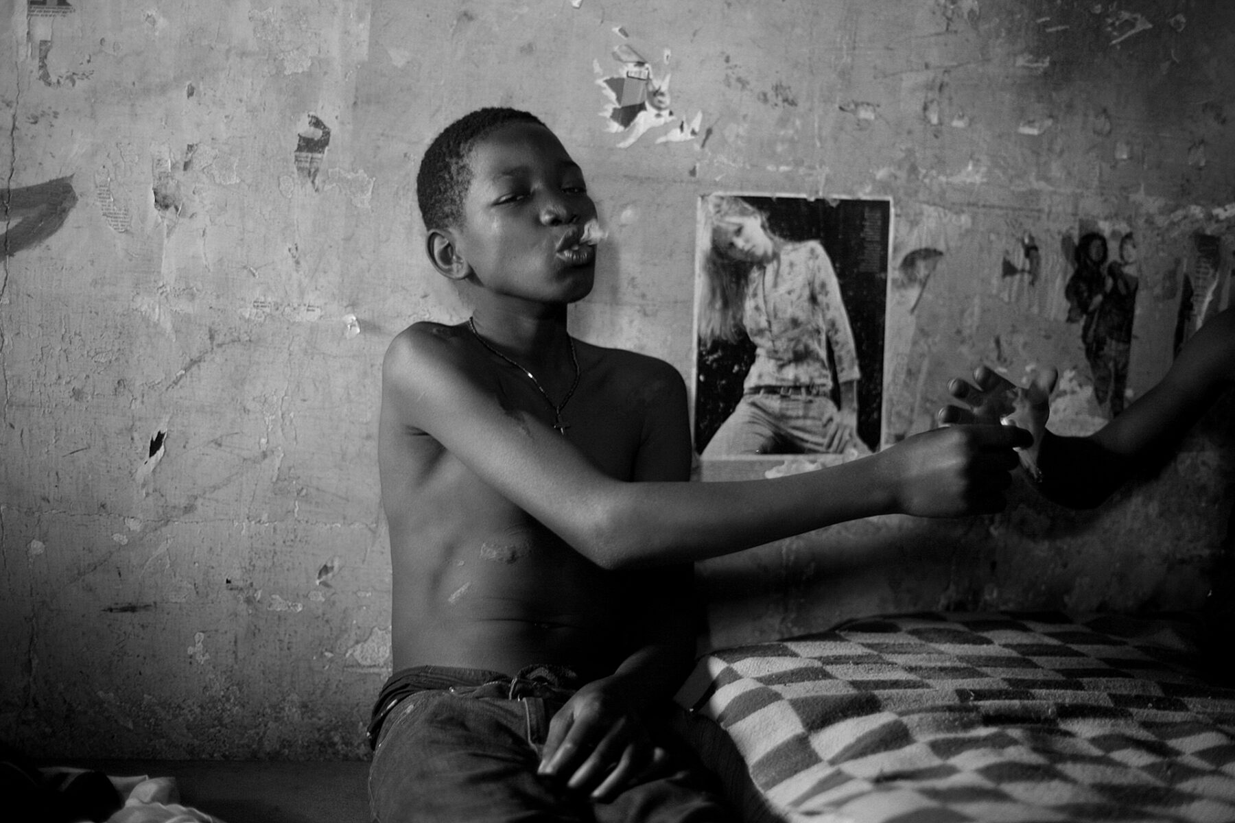 Black and white photography by Mário Macilau, young boy smoking