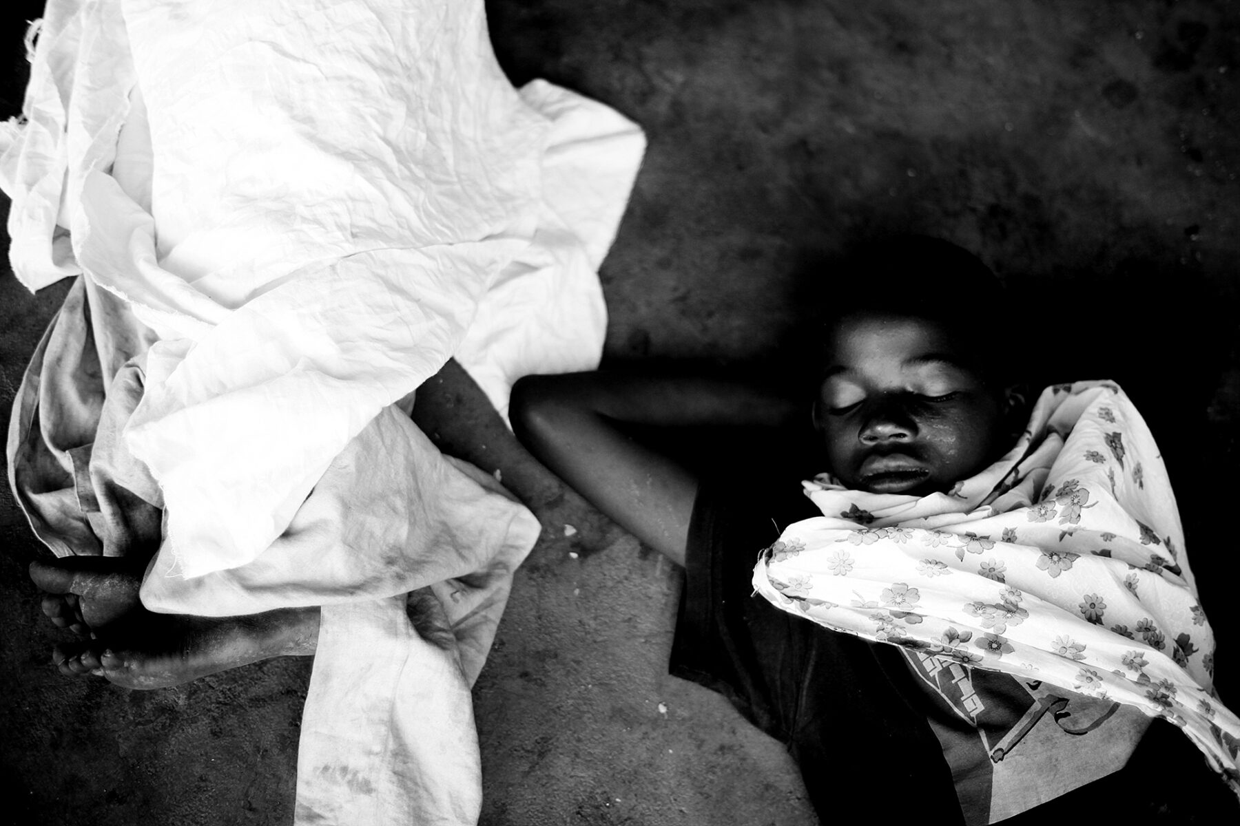 Black and white documentary photography by Mário Macilau, homeless children sleeping