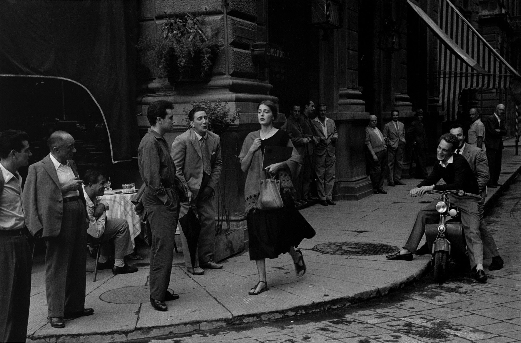 Street photography by Ruth Orkin, woman walking down street, Florence, surrounded by jeering men