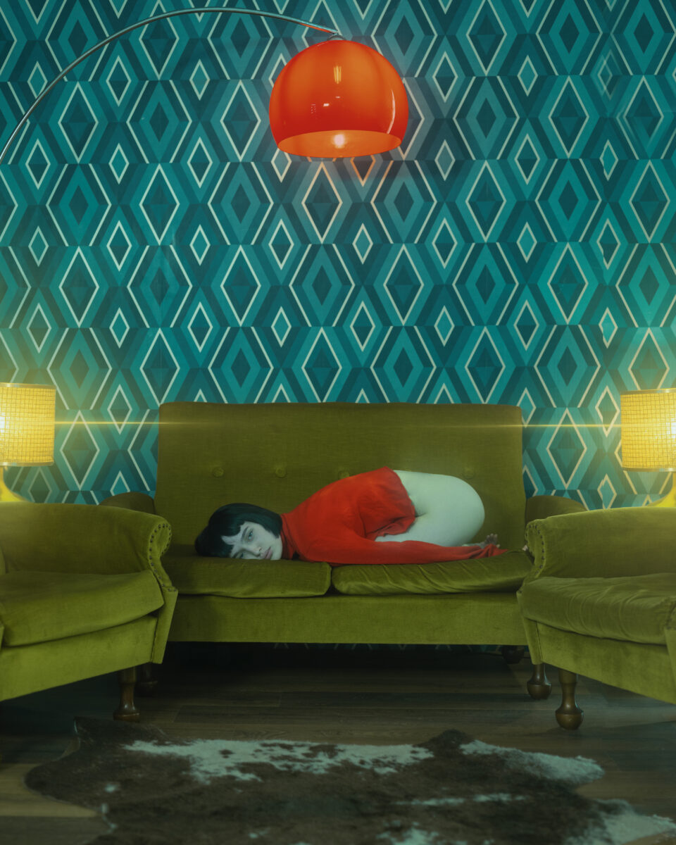 Color photography by Paolo Baretta. Portrait of woman lying on sofa.