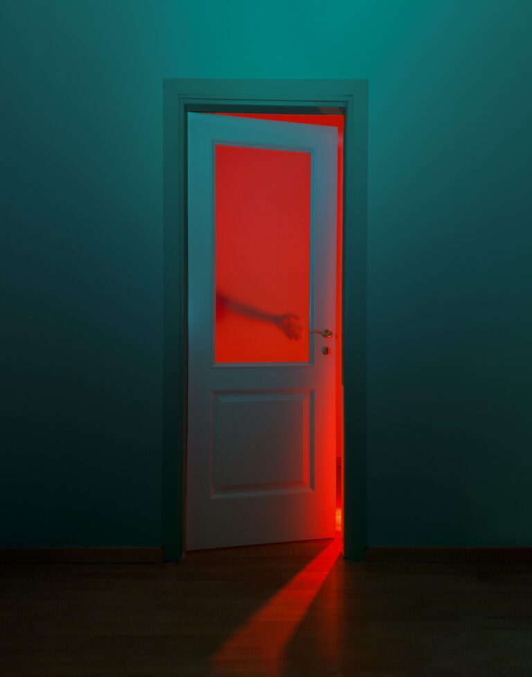 Color photography by Paolo Baretta. Red door, neon, hand