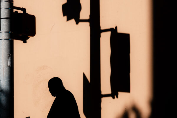 color street photo of street sign and shadows by Branden May