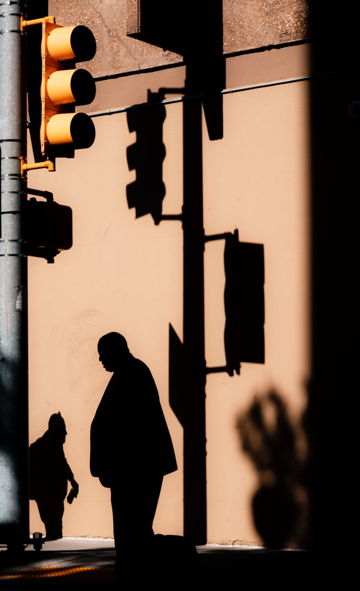 color street photo of street sign and shadows by Branden May