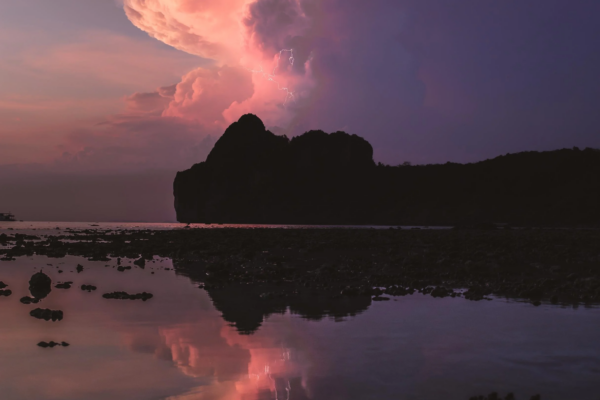 color landscape photo of pink cloud and lightbolts on a coastline by Bennet Witte