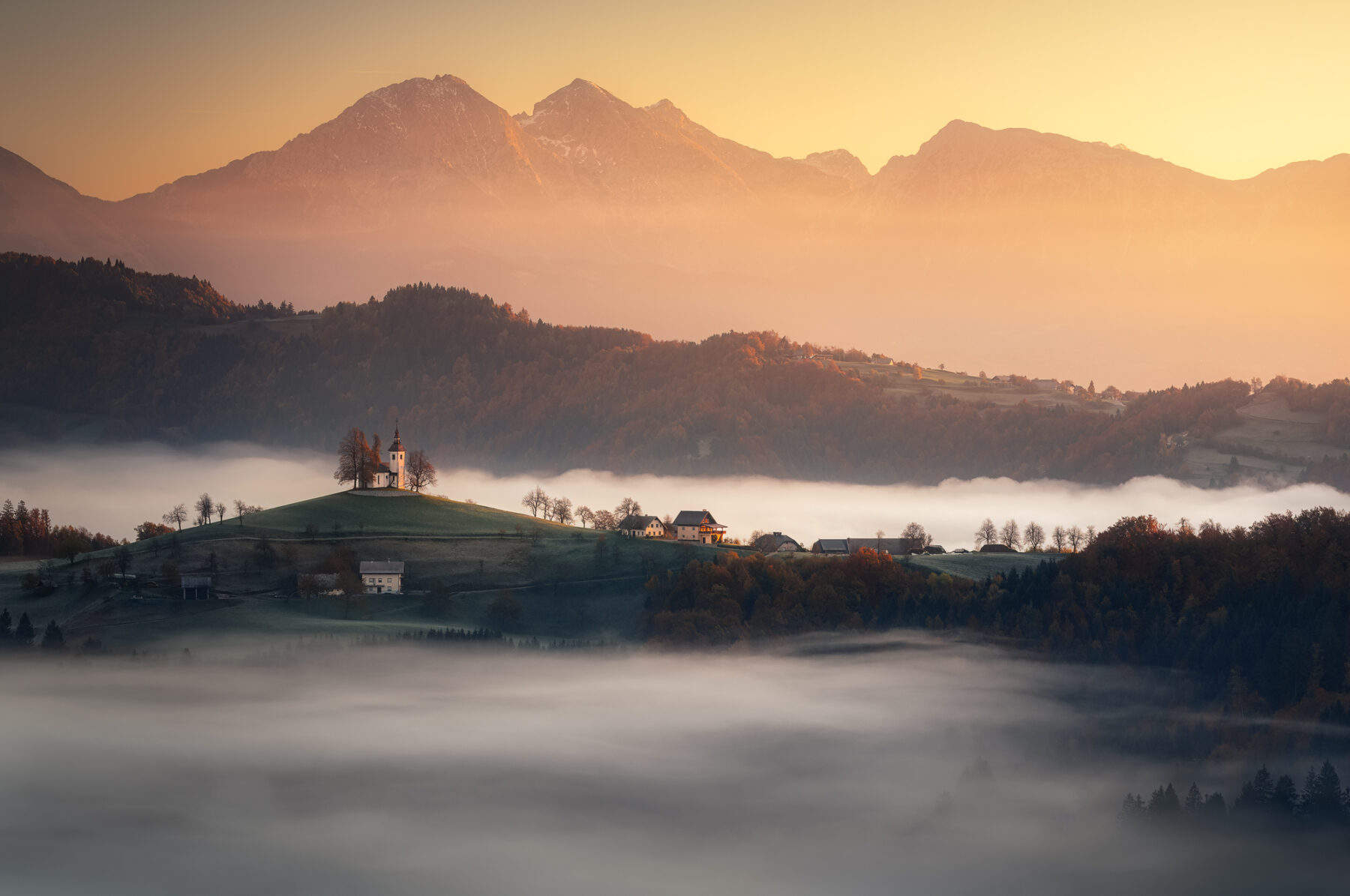 color landscape photo of mountains, village and misty sunrise in Solovenia by Matteo Rovatti