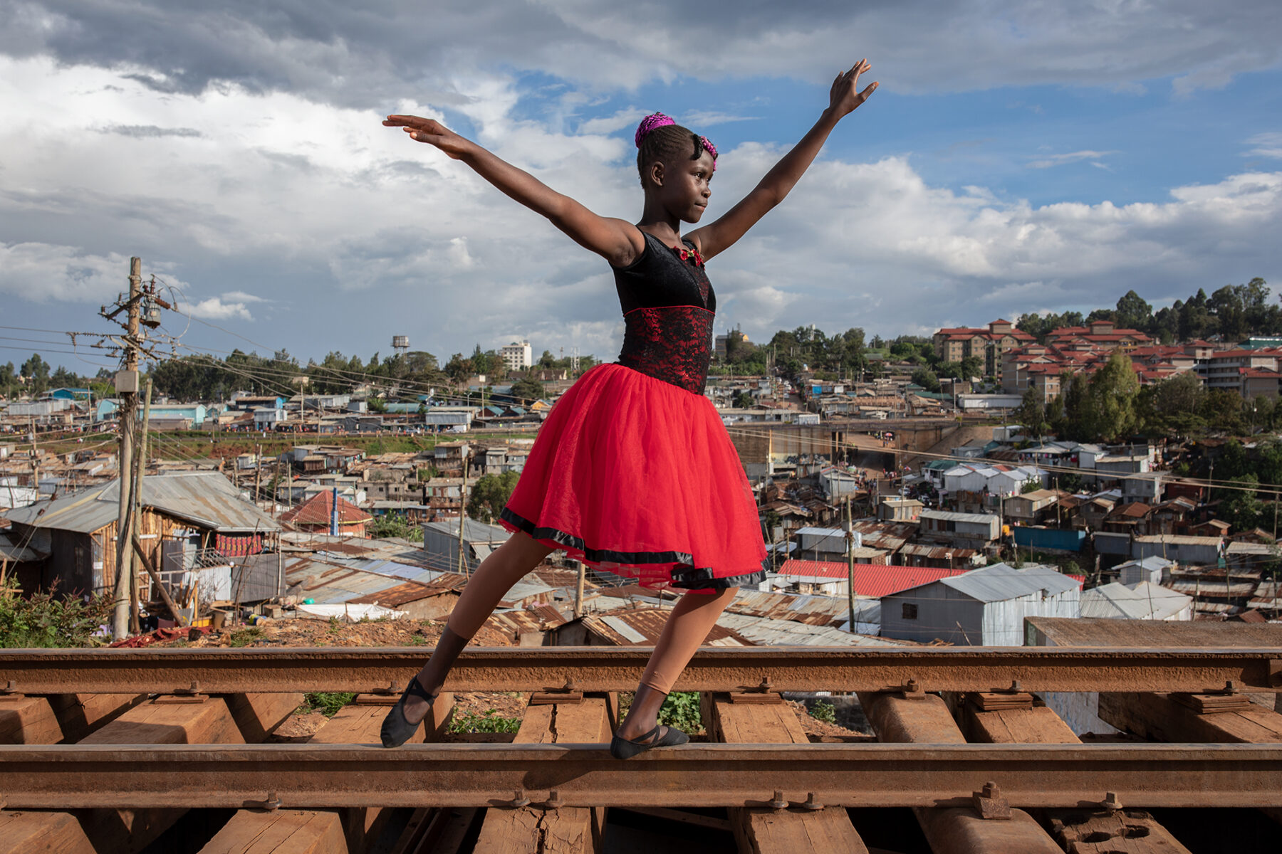 color portrait photo of girl dancing in Kibera, Nairobi, Kenya by Mauro De Bettio