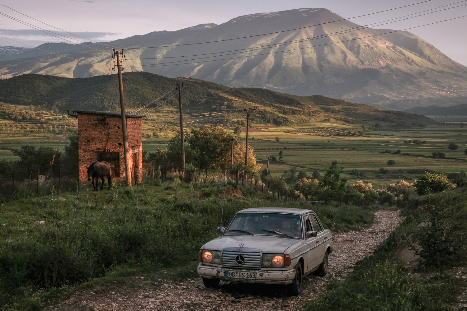 Documentary landscape photography by Nick St. Oegger, mountains, car, fields, Albania