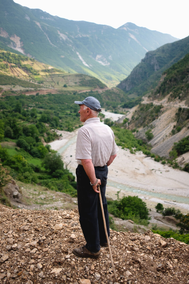 Documentary photography by Nick St. Oegger. Portrait of elderly man looking over a river valley in Albania